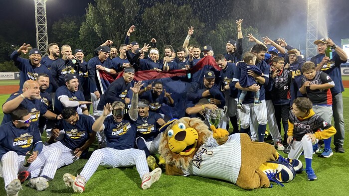Des joueurs célèbrent avec une mascotte.