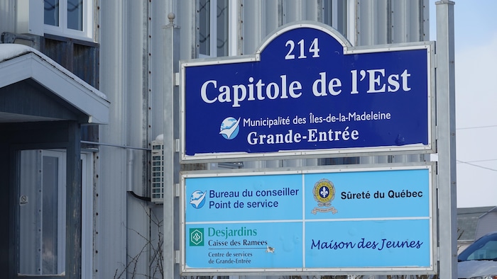 Une pancarte où il est indiqué que le Capitole de l'Est héberge des services de la Sûreté du Québec, de la Maison des jeunes, de Desjardins et de la Municipalité des Îles-de-la-Madeleine.