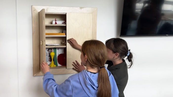 Deux filles de 12 ans ferment une armoire.