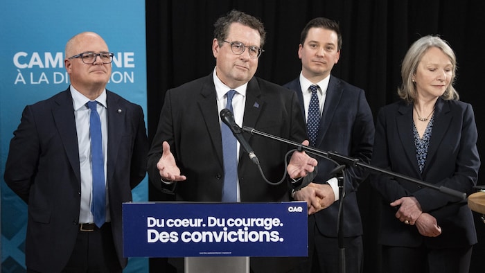 Bernard Drainville (au centre) et, de gauche à droite, le ministre des Transports du Québec, Jonatan Julien, le ministre de la Justice du Québec, Simon Jolin-Barrette, et la ministre de la Santé du Québec, Sonia Bélanger, à Montréal, le lundi 6 avril 2026.