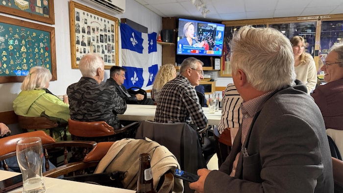 Un militant regarde les résultats à l'écran.