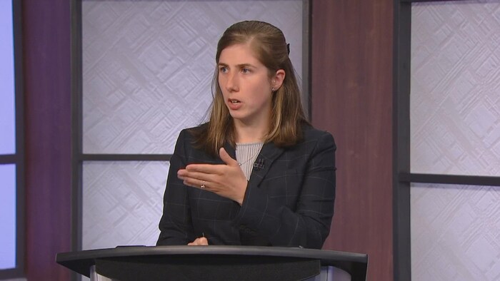 Elle répond à une question lors du débat en français.