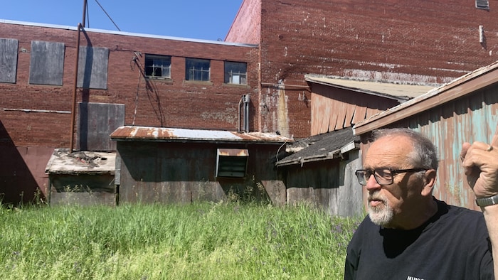 Un homme debout à l'arrière d'une ancienne usine.
