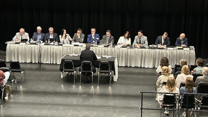 Un groupe de personnes assises devant une table.