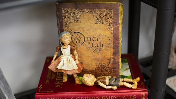 Deux marionnettes devant un livre portant le nom de «Once a Tale». 