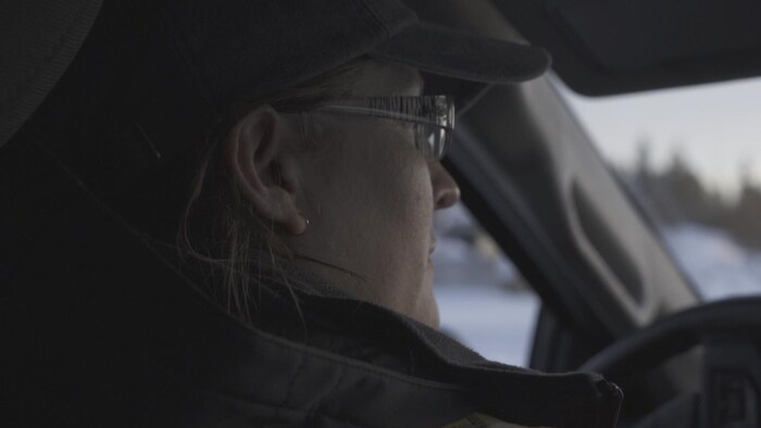 Une femme conduit un véhicule.