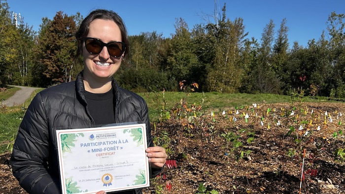 Carine Bélanger pose pour la photo devant la mini-forêt.