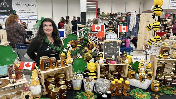  Carla Robson, apicultrice, montre fièrement ses pots de miel fabriqués localement.