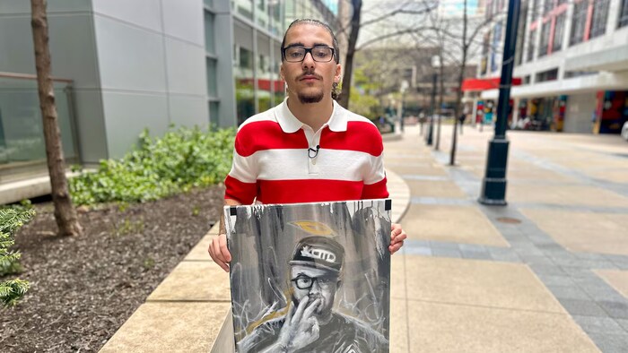Carlito Parra tient un portrait de son père mort du cancer.
