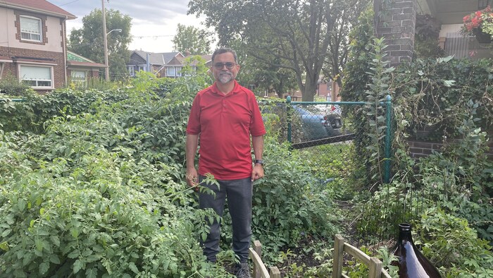 Luis Alberto Mata debout dans un jardin qui regorge de plantes.