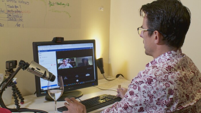 Carl Boucher est devant son ordinateur et discute avec une associée du Québec, sur la plateforme Zoom.
