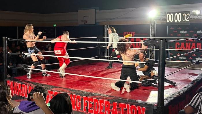 Cinq lutteurs s'affrontent sur un ring.