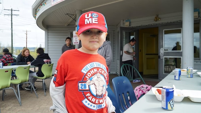 Un enfant porte un t-shirt à l'effigie de John Cena.
