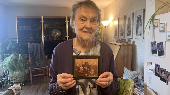 Carmen Laroche tient une vieille photo de membres de sa famille.