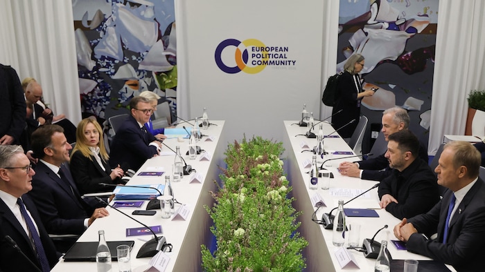 Des dirigeants sont assis à des tables pour débattre.