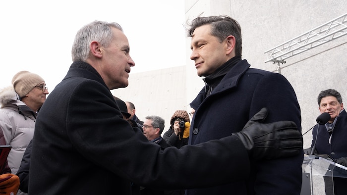 Le candidat à la direction du Parti libéral, Mark Carney, s'entretient avec le chef conservateur Pierre Poilievre avant une cérémonie au Monument national de l'Holocauste, le lundi 27 janvier 2025 à Ottawa.