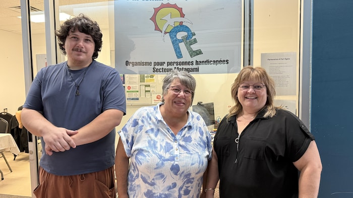 Carole Beaudoin pose avec Marc-André Quirion et Marie-France Boivin devant les locaux de l'organisme Partenaires à part égale.