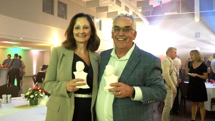 Carole Freynet-Gagné et Louis Tétrault tiennent une statuette de Louis Riel.