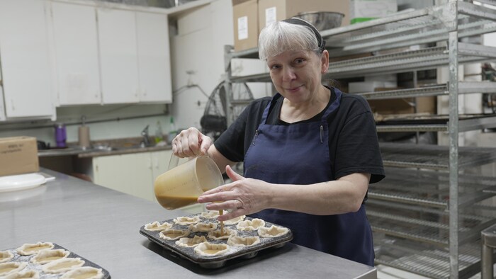Carol Jetté coule du sirop d'érable dans des tartelettes confectionnées par le boulanger.