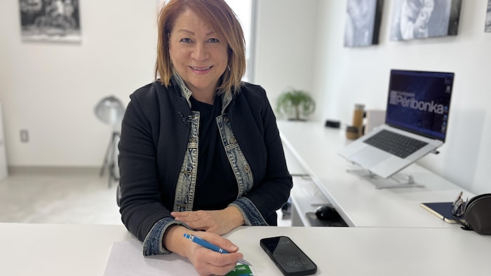 Carole Tremblay prend la pose pour la photo dans son bureau à Péribonka.