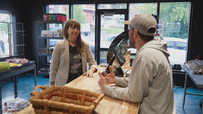 Caroline Dubé parle à un commerçant.