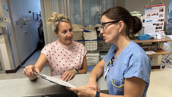Deux professionnelles de la santé discutent aux soins intensifs.