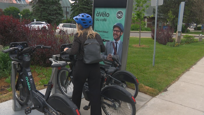 Elle décroche un vélo de l'ancrage.