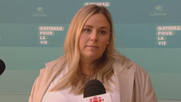 Une femme s'adresse aux médias lors d'une conférence de presse.