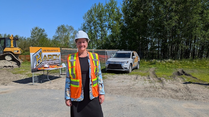 Caroline Roy devant un chantier de construction.