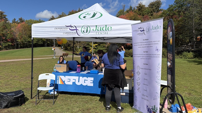 Une table avec des bénévoles et des employés, dans un parc.
