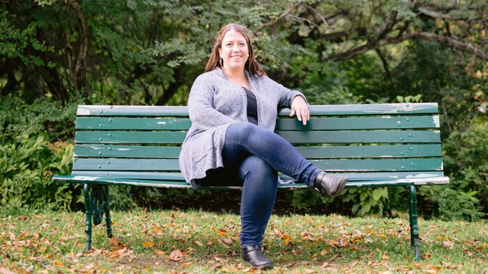 Une femme assise sur un banc de parc.