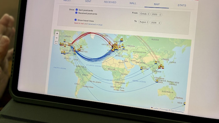 Un écran de tablette tactile montrant une carte du monde. Des fils rouges montrent les cartes envoyées, et les fils bleus celles reçues.
