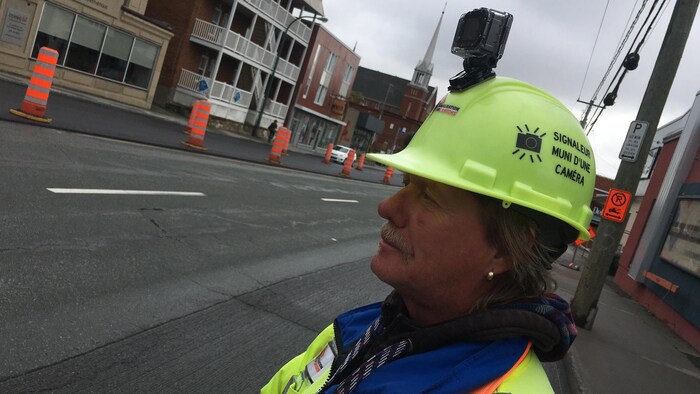 Un signaleur routier avec un casque muni d'une caméra vidéo.