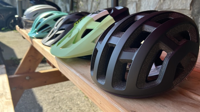 Des casques de vélo sont disposés sur une table.