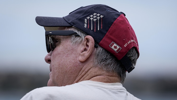 Un homme porte une casquette des Snowbirds.