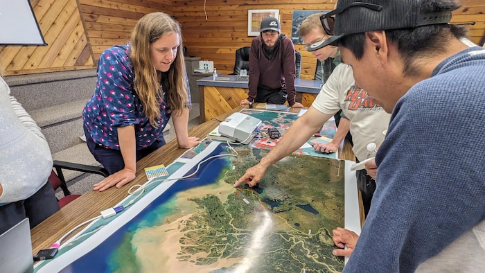 Un groupe de personnes regardent une carte géographique.