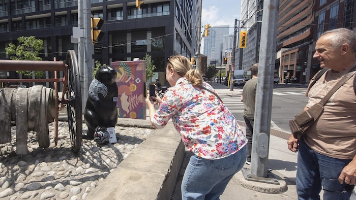 Natalie Pieri, une touriste venue de France, prend une photo du castor néo-zélandais sous le regard de son mari Patrick, à Toronto, le vendredi 5 juin 2026. 