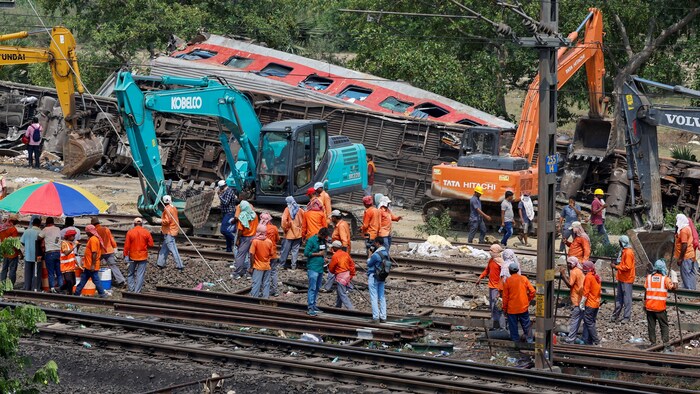 Des machines lourdes retirent les wagons endommagés des voies ferrées sur le site d'une collision ferroviaire après l'accident meurtrier dans le district de Balasore dans l'État oriental d'Odisha.