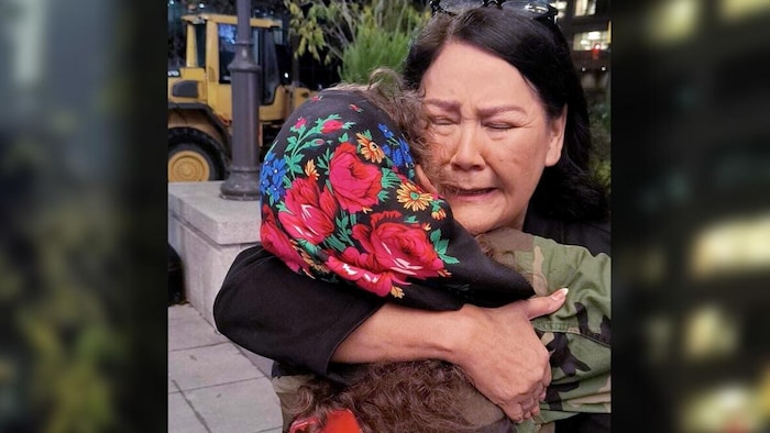 AMC Grand Chief Cathy Merrick embraces Cambria Harris on Tuesday night upon hearing NDP Leader Wab Kinew will become Manitoba's next premier. Police believe Harris's mother Morgan Harris was among four women killed by an alleged serial killer and that her remains are located at Prairie Green landfill. (Viv Ketchum/Facebook)