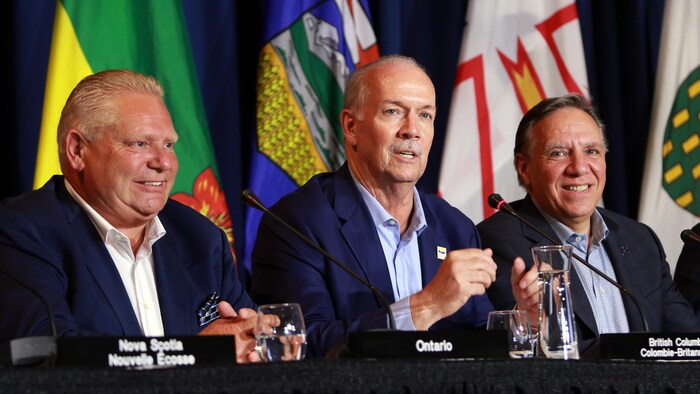 Les premiers ministres de l'Ontario, Doug Ford (à gauche), de la Colombie-Britannique, John Horgan (au centre), et du Québec, François Legault (à droite), répondent aux questions des médias au dernier jour de la rencontre des premiers ministres canadiens à l'hôtel Empress de Victoria, en Colombie-Britannique, le mardi 12 juillet 2022.