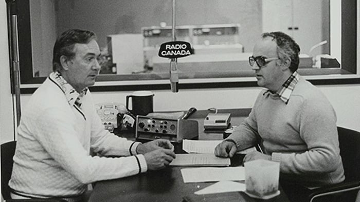 Deux hommes discutent autour d'un micro.