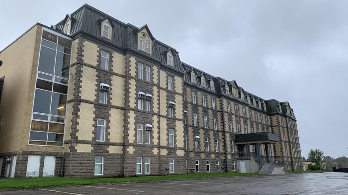 Un bâtiment imposant et un stationnement entièrement vide de voitures. 