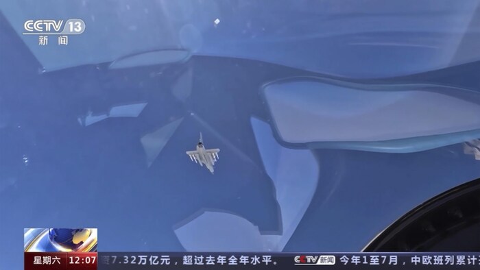Cumartesi günü Çin televizyonunda gösterilen bir videodan alınan görüntü, su üzerinde uçan bir askeri uçağı gösteriyor.