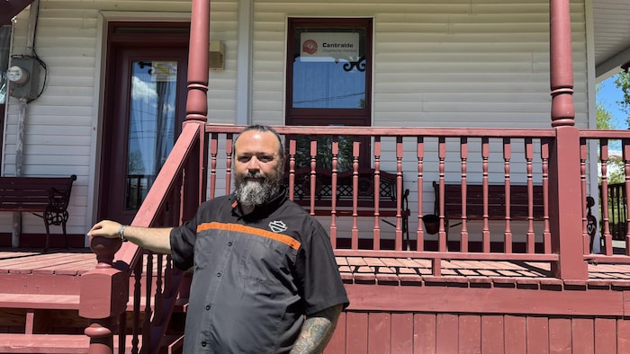 Un homme devant une maison.
