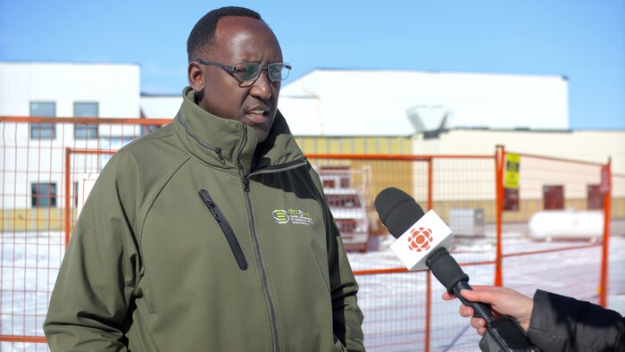Le représentant du Collectif des parents inquiets et préoccupés (CPIP), Jean de Dieu Ndayahundwa, devant le chantier de la nouvelle école francophone de Regina, ;e 1er mars 2024.