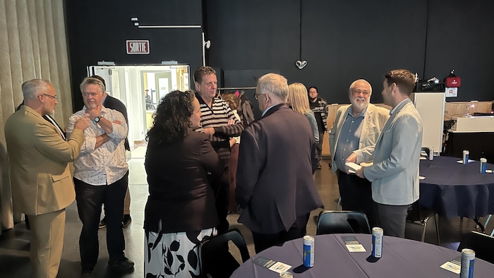 Plusieurs personnes discutent ensemble dans un salle.