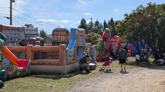 Des structures gonflables colorées et des familles se rassemblent en plein air,