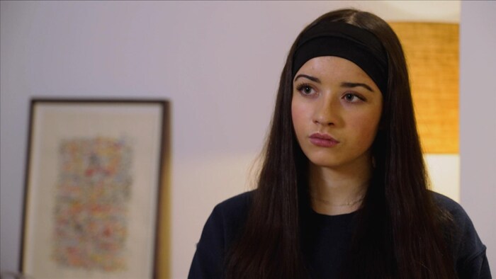 Une jeune femme regarde son interlocuteur.