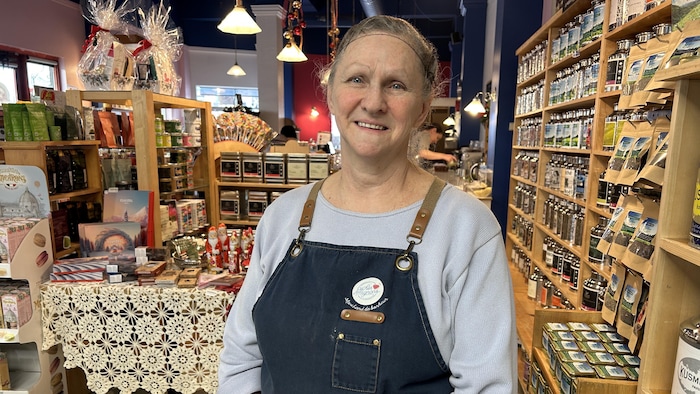 Céline Bilodeau prend la pose devant sa boutique remplie de chocolats, de thés et de confiseries de tous genres.