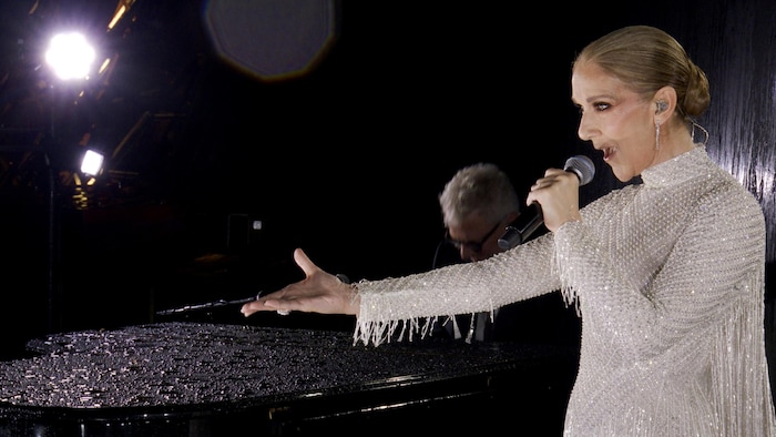 Céline Dion chante près d'un piano.